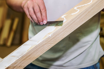 Joinery work. Apply the adhesive on a wooden surface