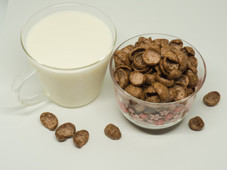 Chocolate breakfast cereal and a cap of milk.