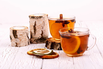 two cups of black tea,dried lemons lying on white floor