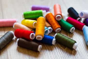 multicolored bobbin of thread on a wooden background
