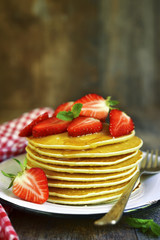 Pancakes with honey and strawberry.