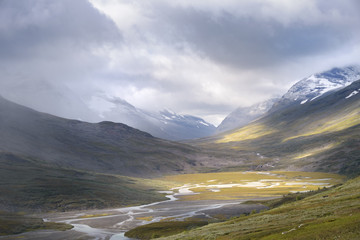 Flusstal beleuchtet von goldenem Sonnenlicht im Herbst schneebedeckte Berglandschaft © Wouter