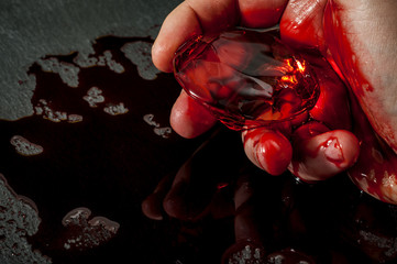 Closeup on hand holding a diamond covered in blood concept of the term conflict diamond with copy...