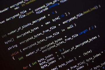 Computer code language on a computer screen. Focus point on the encrypted word.