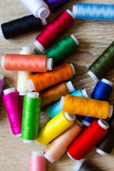 multicolored bobbin of thread on a wooden background
