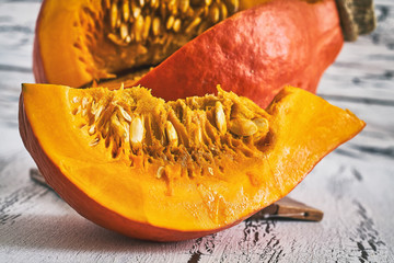 Red kuri squash (Hokkaido pumpkin) on white rustic wooden background