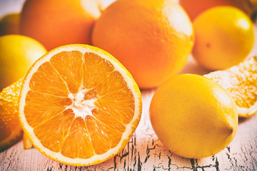 Oranges and lemons on white rustic wooden background
