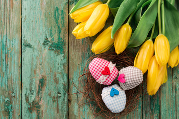 Easter background yellow tulips on wooden table, Rabbit, eggs,nest candy