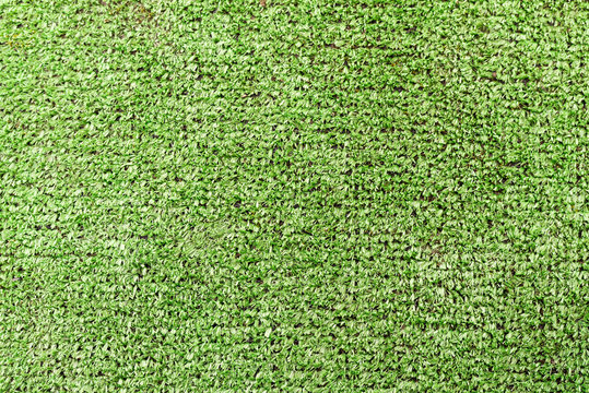 Background. Texture of artificial plastic sheeting imitating a green grass