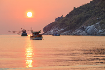 fishing boats at sunset on tropical beach of Thailand