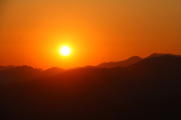 Orange sky with strong sunlight over the mountains