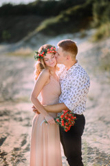 charming and young man and woman standing together on sand