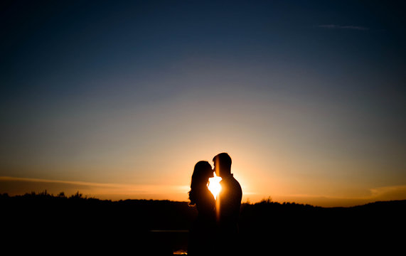 silhouettes of men and women in love at sunset