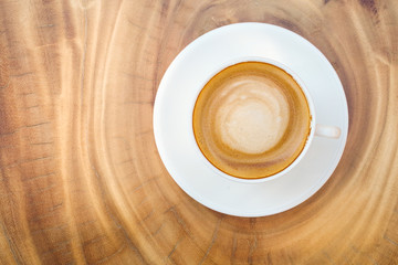 Top view of hot coffee cappuccino cup with milk foam on wood tab