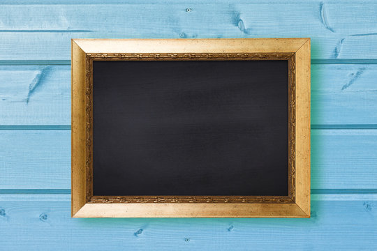 Chalkboard in vintage frame on blue wooden wall texture