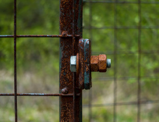 The old and rusty lock on a metal gate.