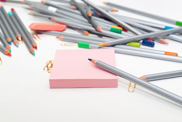 color pencils scattered on table with notepad. Nobody. Antistress