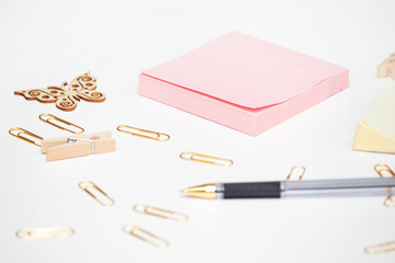 Top view of blank of paper sheet, gold stationery items, several drawing tools decorated with wooden butterfly