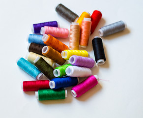 multicolored spools of thread on white background