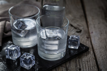Vodka in shot glasses on rustic wood background