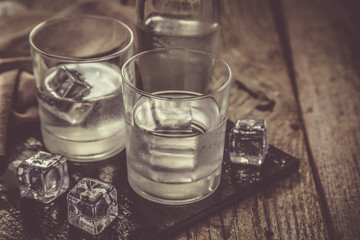 Vodka in shot glasses on rustic wood background