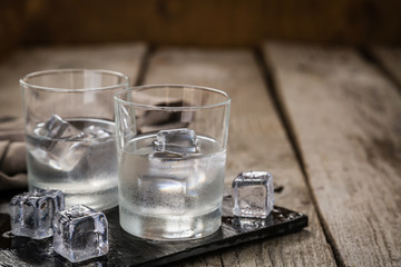 Vodka in shot glasses on rustic wood background - obrazy, fototapety, plakaty