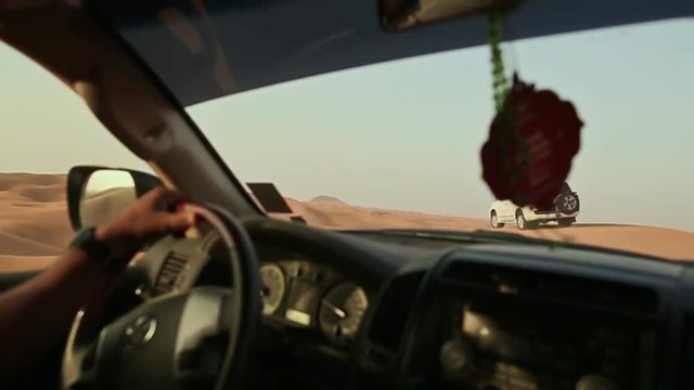 Desert Safari SUVs bashing through the arabian sand dunes. View from the car 1.