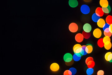 Colorful bokeh on a black background. New Year, Christmas wallpaper