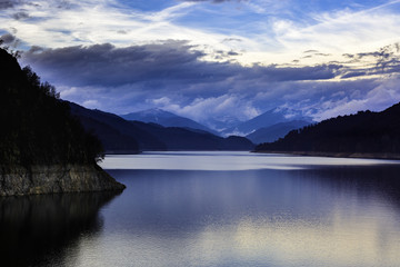 Obraz premium Landscape with dam lake Vidraru in Romanian mountains, in the wi