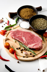 raw steak  round wooden cutting board spices