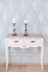 white dresser in the light room and candlesticks from silver. An interior in classical style