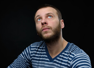 Casual man looking up over black background