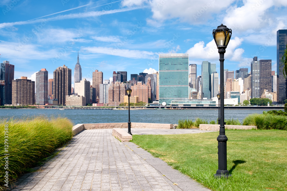 Sticker the midtown manhattan skyline on a summer day seen from a beautiful park in queens