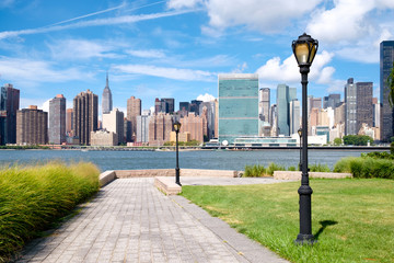 The midtown Manhattan skyline on a summer day seen from a beautiful park in Queens