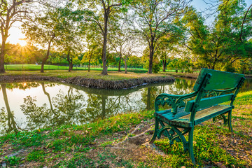 Fototapeta na wymiar Green wood bench in summer park