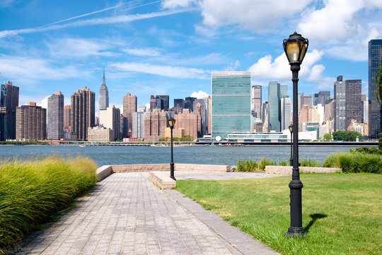 The midtown Manhattan skyline on a summer day seen from a beautiful park in Queens © kmiragaya