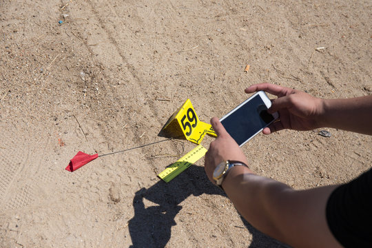 forensic hand use mobile phone take picture of evidence with evidence marker 