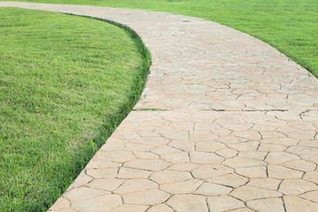 Fototapeta premium Stone Pathway in a Lush Green Park.