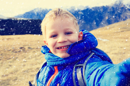 little boy making selfie while travel in mountains