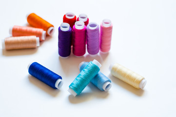 multicolored spools of thread on white background