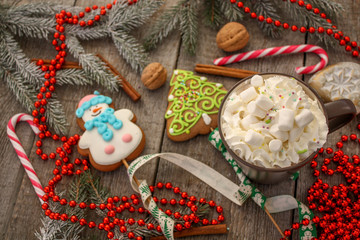 christmas background, composition. spruce branches, gingerbread (Snowman and Christmas tree), cocoa with cream and marshmallows, cinnamon, candy cane.