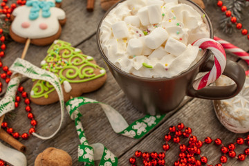 christmas background, composition. spruce branches, gingerbread (Snowman and Christmas tree), cocoa with cream and marshmallows, cinnamon, candy cane.