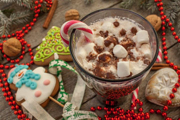 christmas background, composition. spruce branches, gingerbread (Snowman and Christmas tree), cocoa with cream and marshmallows, cinnamon, candy cane.