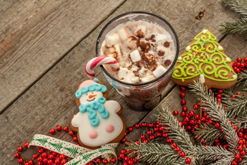 christmas background, composition. spruce branches, gingerbread (Snowman and Christmas tree), cocoa with cream and marshmallows, cinnamon, candy cane.