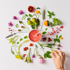 Various natural things neatly arranged in circle with smoothie