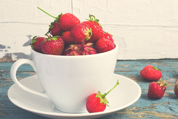 Ripe garden strawberries in white cup, tinted