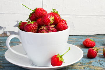 Ripe garden strawberries in white cup