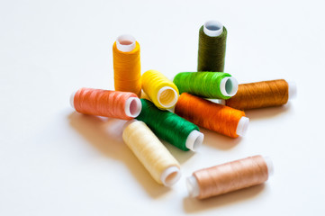 multicolored spools of thread on white background