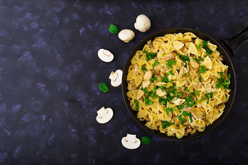 Farfalle pasta with chicken and mushrooms in a creamy sauce. Top view