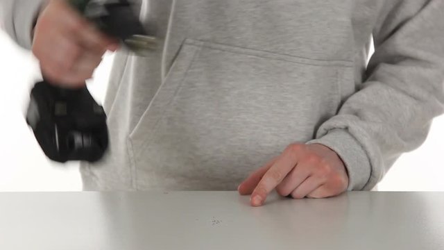 Man's hands close-up making a hole in the tabble with the drill